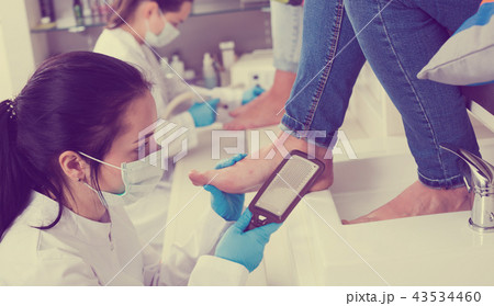 Nail technicians giving pedicure 43534460