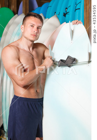 Athletic guy surfer posing with surfboard Athletic guy surfer posing with surfboard 43534595