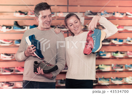 Girl and guy choosing clothes and shoes for sports 43534700