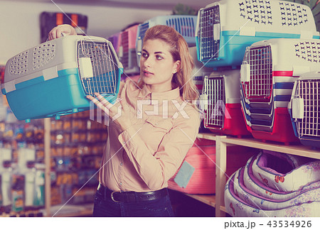 Woman looking for pet carrier cage in shop Woman looking for pet carrier cage in shop 43534926