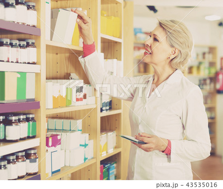 Aged female seller is checking assortment Aged female seller is checking assortment 43535016