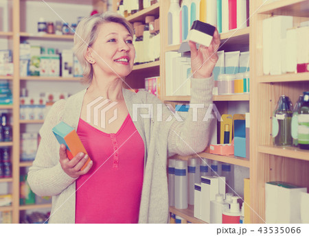 Attractive female client browsing rows of skin care products 43535066