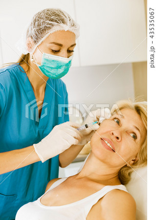 Mature female receiving cosmetic injection 43535067