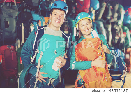 young couple of travelers at sports store, selects backpacks for camping young couple of travelers at sports store, selects backpacks for camping 43535187