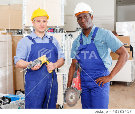 Builders using manual power tools 43535417