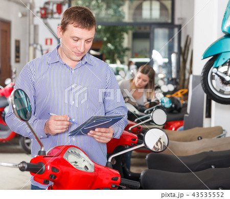 Man is shopping and choosing new motobike Man is shopping and choosing new motobike 43535552