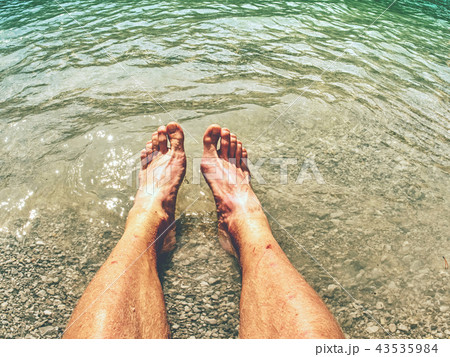Legs in wave of water and rough white stony sand Legs in wave of water and rough white stony sand 43535984