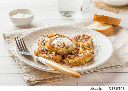 Fried zucchini slices in egg batter with garlic  43536508
