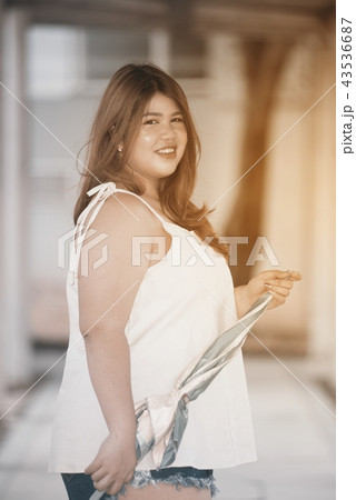 Asian pretty fat woman hold a umbrella on walkway. Asian pretty fat woman hold a umbrella on walkway. 43536687