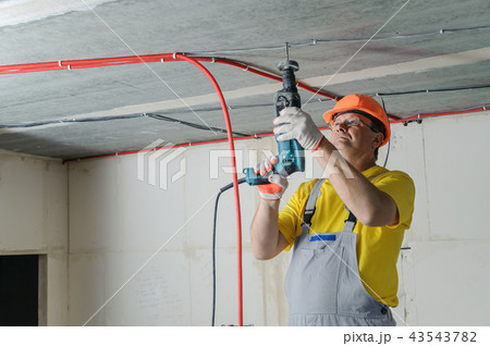 The worker is plastering the electric tubes. 43543782