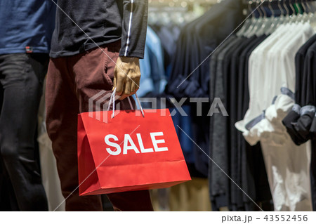 Part of male mannequin dressed in casual clothes holding the Sales paper shopping bag in the shopping department store for shopping, business fashion and advertisement concept Part of male mannequin dressed in casual clothes holding the Sales paper shopping bag in the shopping department store for shopping, business fashion and advertisement concept 43552456