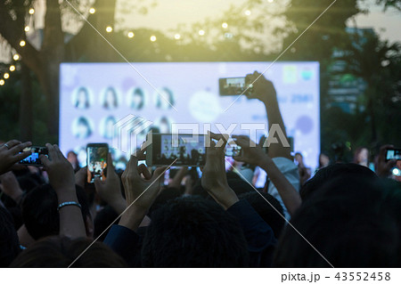 Fan club people taking photographs by smart phone during music entertainment public concert outdoor in evening time, Musical and concert concept Fan club people taking photographs by smart phone during music entertainment public concert outdoor in evening time, Musical and concert concept 43552458