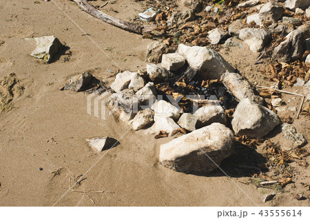 campfire strewn with stones and leaves in a beach campfire strewn with stones and leaves in a beach 43555614
