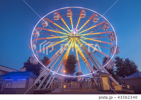 Ferris wheel in motion against the blue sky 43562340