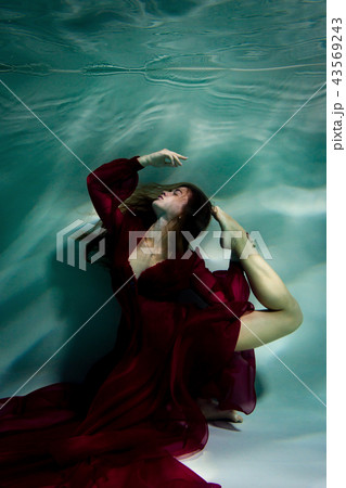 Woman under the water in a red dress. Woman under the water in a red dress. 43569243