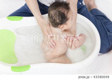 新生児の入浴 沐浴方法を説明するマニュアル用写真 背中 背部 後ろの洗い方の写真素材
