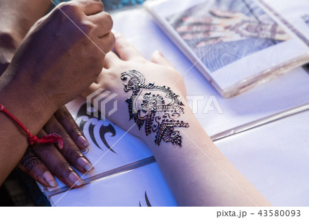 Artist grafting temporary henna mehendi tattoo art 43580093
