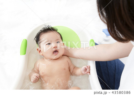 新生児の入浴 沐浴方法を説明するマニュアル用写真 沐浴時の新生児の安心 安定する支え方イメージの写真素材