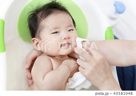 新生児の入浴 沐浴方法を説明するマニュアル用写真 洗髪 洗顔後の拭き方 仕上げの写真素材