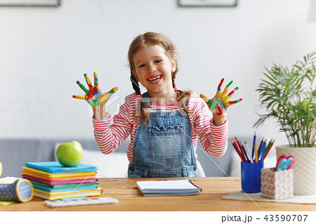 funny child girl draws laughing shows hands dirty with paint 43590707