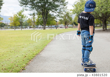 小学1年生のスケボー少年の後ろ姿の写真素材