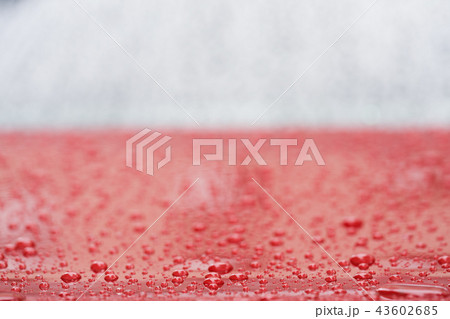 Closeup rain drops on red car with hydrophobic coating 43602685