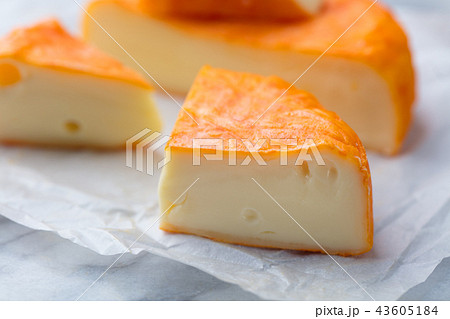 Cheese with washed orange rind. French or German. Marble table background. Cheese with washed orange rind. French or German. Marble table background. 43605184