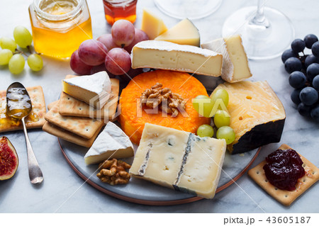 Assortment of cheese, grapes with red and white wine in glasses. Marble background. Top view. 43605187