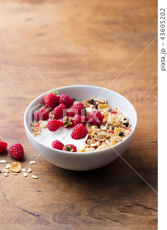 Healthy breakfast. Fresh granola, muesli with yogurt and berries on wooden background. Copy space. Healthy breakfast. Fresh granola, muesli with yogurt and berries on wooden background. Copy space. 43605202