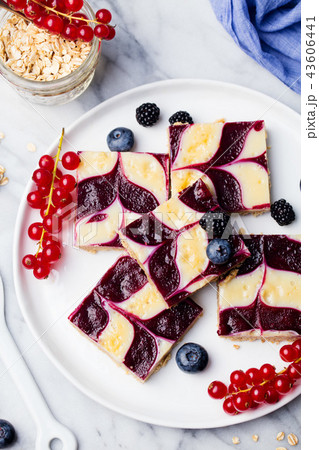 Oatmeal, oat bars with fresh berries on a white plate. Marble background Healthy breakfast. Top view 43606441
