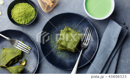 Matcha green tea cake, bars, brownie with white chocolate on a plate. Grey background. Top view. Matcha green tea cake, bars, brownie with white chocolate on a plate. Grey background. Top view. 43606525