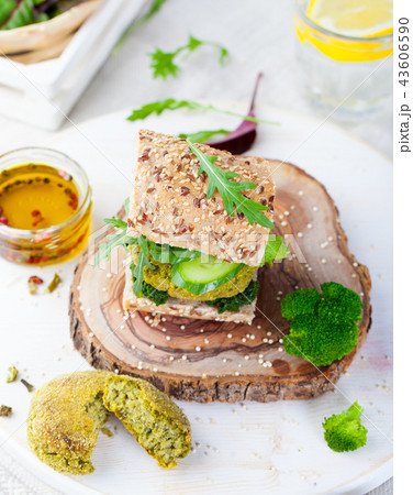 Healthy vegan burger with broccoli and spinach patty on a cutting wooden board. 43606590