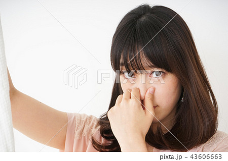 臭い洗濯物の匂いを嗅ぐ若い女性 43606663
