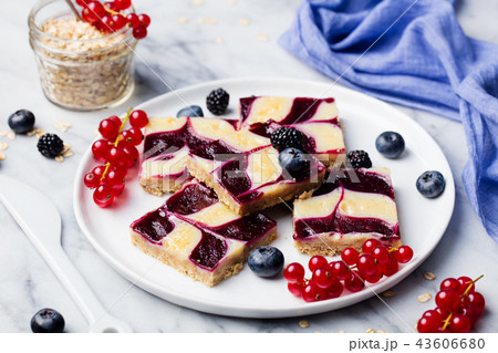 Oatmeal, oat bars with fresh berries on a white plate. Marble background. Healthy breakfast. Oatmeal, oat bars with fresh berries on a white plate. Marble background. Healthy breakfast. 43606680