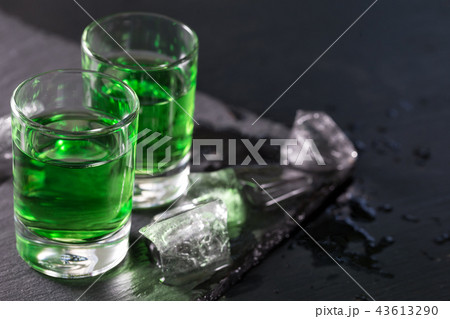 Two glasses of absinthe and melted ice cubes 43613290