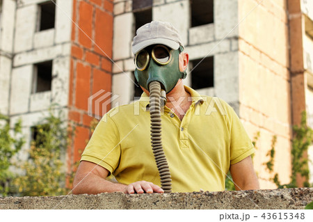 Men in vintage gas mask against ruined building. Men in vintage gas mask against ruined building. 43615348