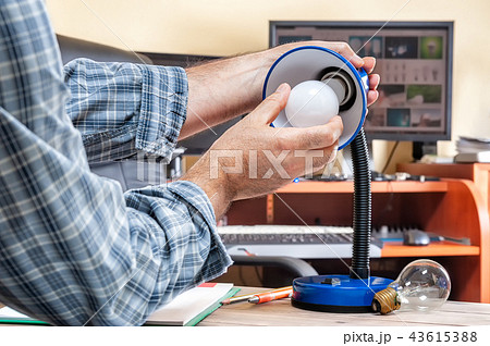 Electrician technician at work installs led bulb 43615388