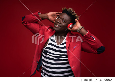 Joyful man listening music on red background 43615602