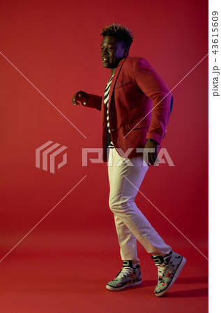 Cheerful man is dancing on red background 43615609