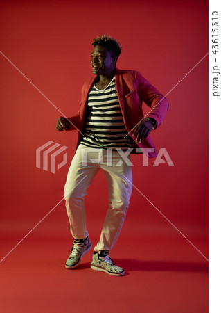 Smiling man with dreadlocks is making dance moves Smiling man with dreadlocks is making dance moves 43615610