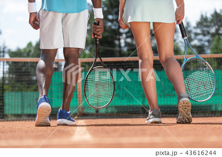 Two tennis players are standing before net outdoor 43616244