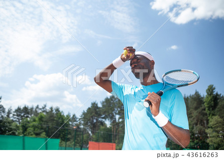 Tennis player is preparing to serve under sun 43616263