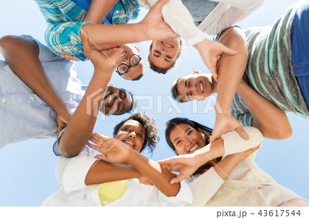 happy smiling friends outdoors standing in circle 43617544