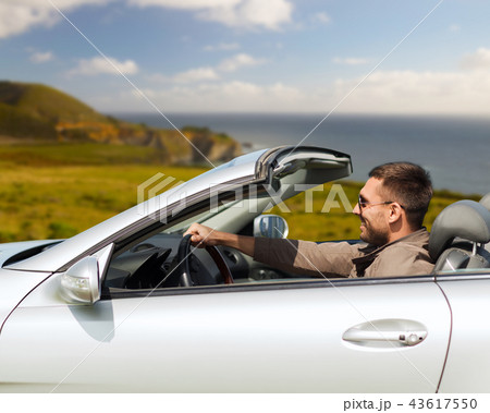 happy man driving convertible car 43617550