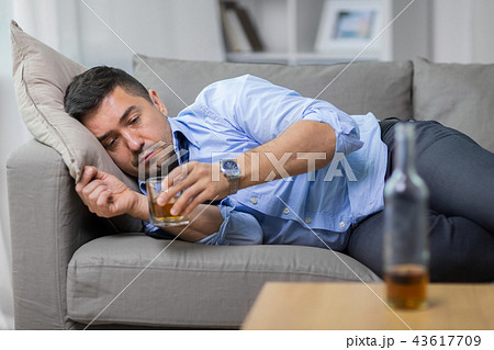 alcoholic lying on sofa and drinking whiskey alcoholic lying on sofa and drinking whiskey 43617709