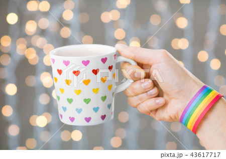 hand with cup of cacao and gay awareness wristband hand with cup of cacao and gay awareness wristband 43617717