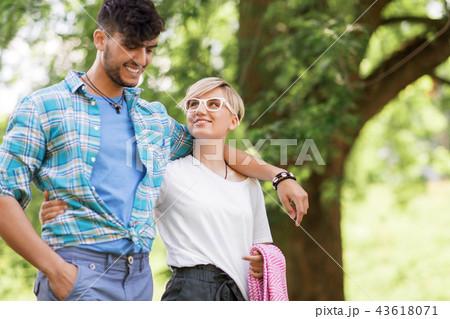 happy couple with picnic blanket at summer park 43618071