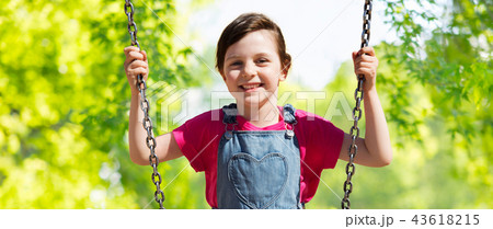 girl swinging on swing over natural background 43618215