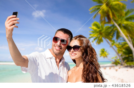 couple making selfie by smartphone over beach 43618526