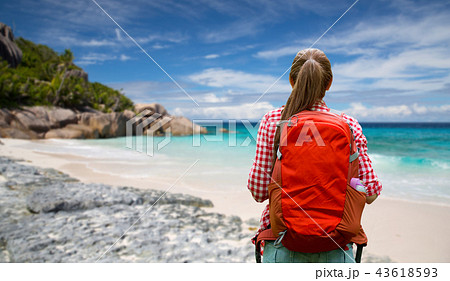 woman with backpack over seychelles beach woman with backpack over seychelles beach 43618593